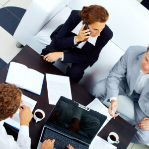 Image of company of successful partners discussing business plan at meeting