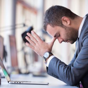 frustrated young business man working on laptop computer at office