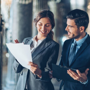 Smiling business persons looking at documents