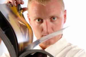 businessman thumbs through magazine