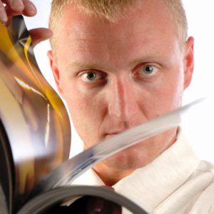 businessman thumbs through magazine