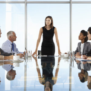 Group Of Business People Having Board Meeting Around Glass Table.