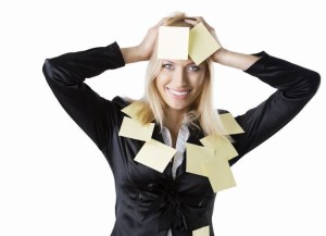 pretty business woman with black jacket and some post-it on her body, she looks in to the lens and smiles and her both hads are on the head